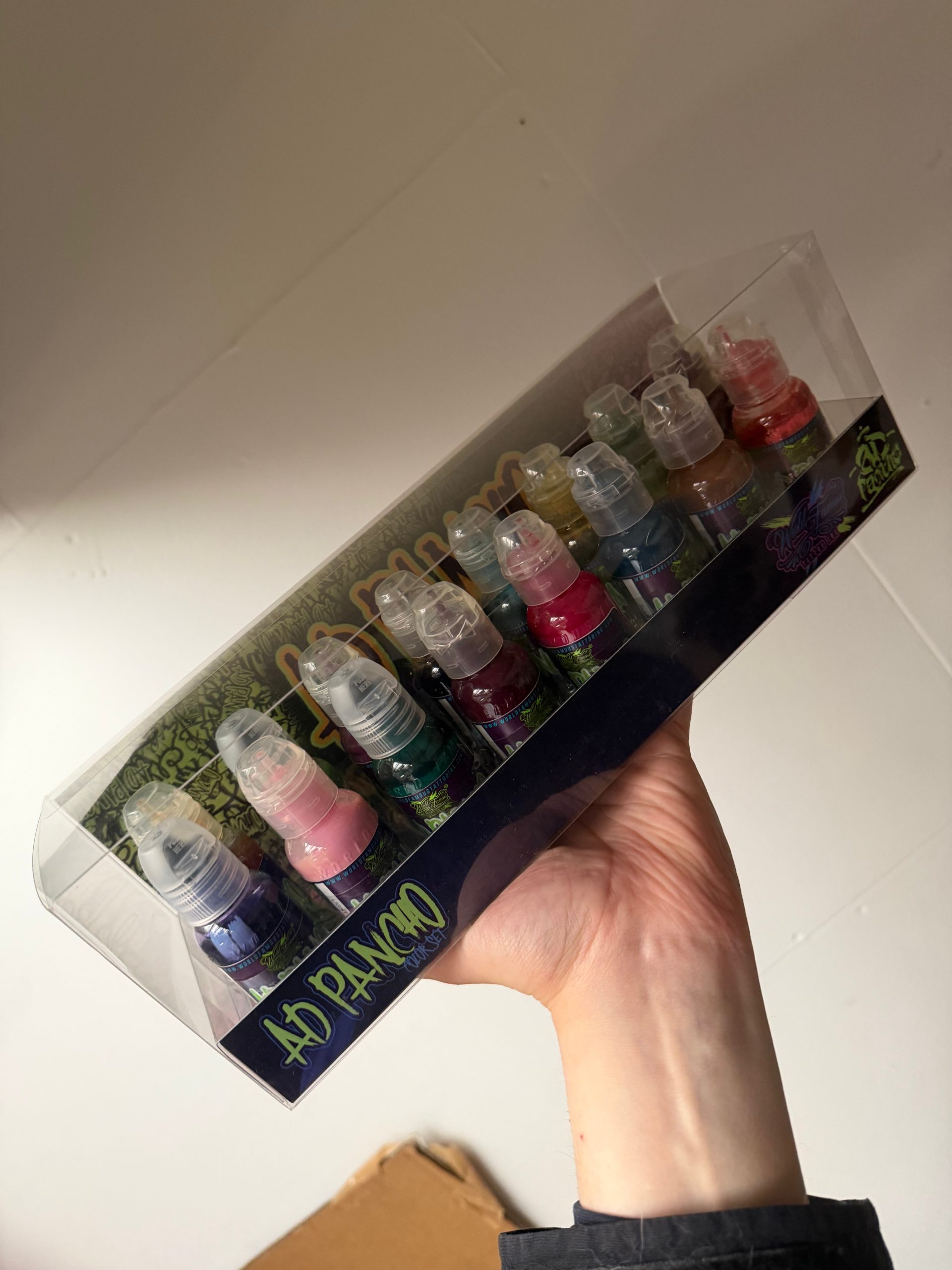 a.d. pancho - world famous ink - 16 colour set - jordan holding up the set in the saviour tattoo supplies office